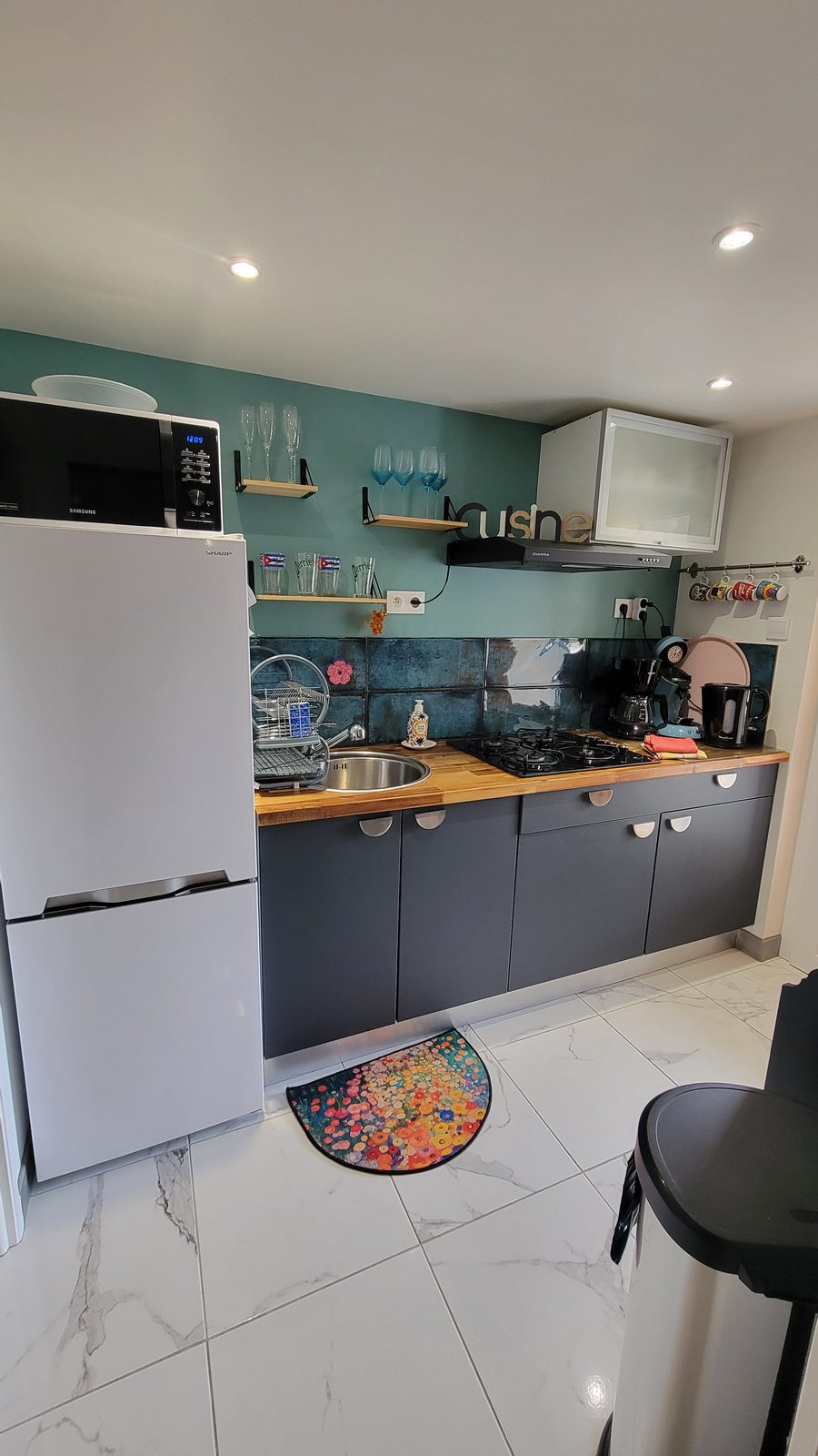 Cuisine équipée de l’appartement, avec porte donnant sur le jardin